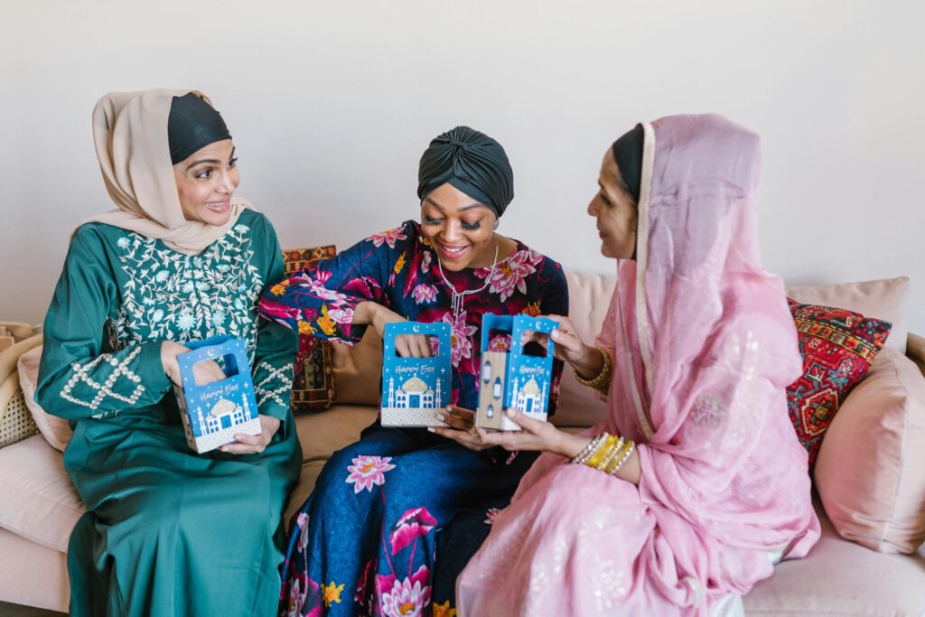 3 Women Sitting on Couch opening gift box